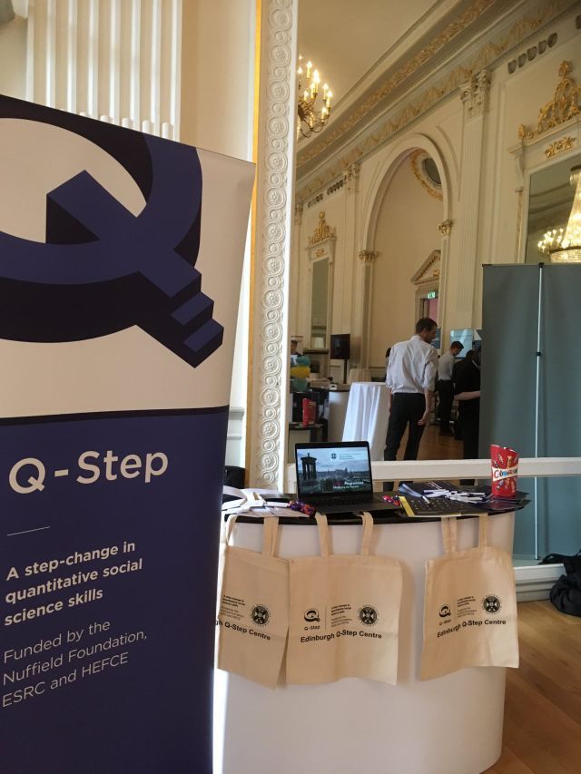 Q-step pop-up stand and branded tote bags on exhibition stall