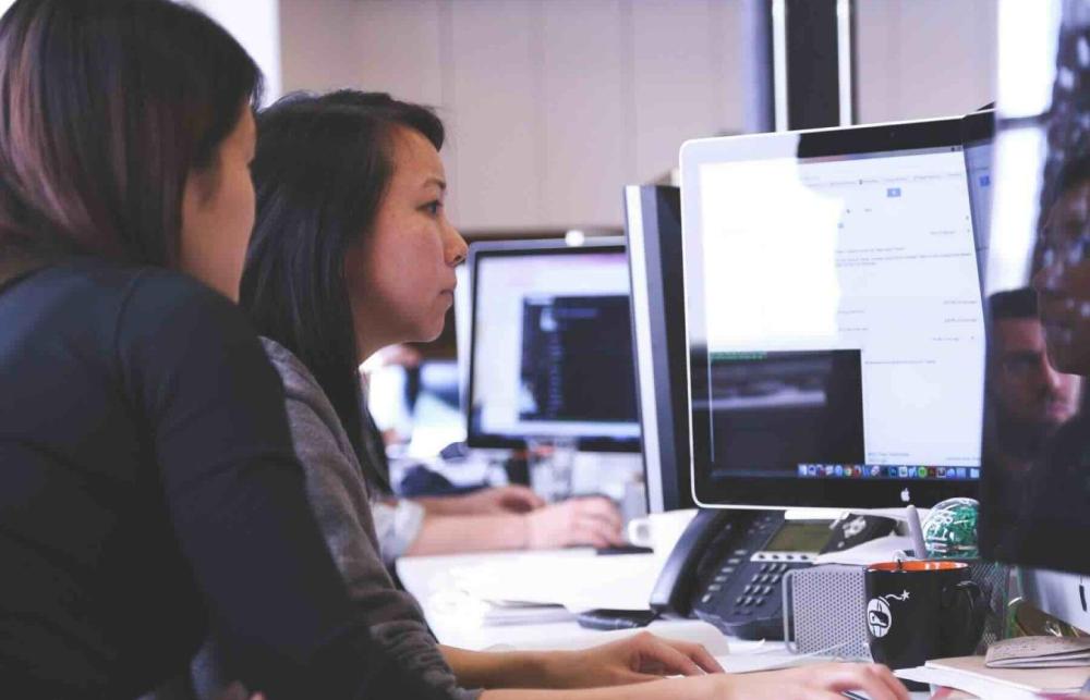 Students working together with data on computers